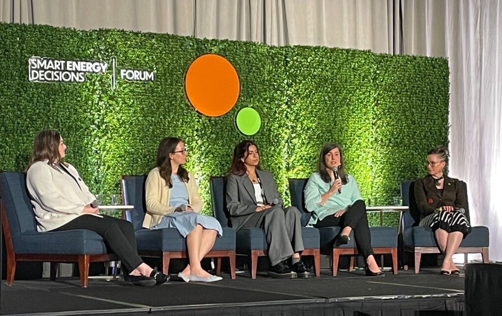 Five panelists sit on a stage