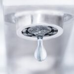 A water droplet falls out of a faucet.