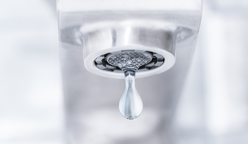 A water droplet falls out of a faucet.